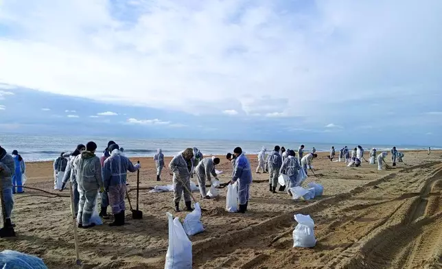 In this photo released by Krasnodar Gov. Veniamin Kondratyev in his Telegram channel on Sunday, Jan. 5, 2025, rescuers and volunteers work to clean up tons of fuel oil that spilled out of two storm-stricken tankers more than two weeks ago in the Kerch Strait, near Anapa in Russia's southern Krasnodar region. (Krasnodar Gov. Veniamin Kondratyev Telegram channel via AP)