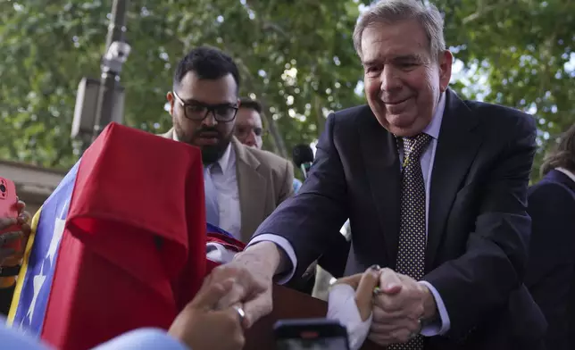 Venezuela's opposition leader Edmundo Gonzalez Urrutia holds hands with a supporters outside the government residence in Montevideo, Uruguay, Saturday, Jan. 4, 2025. Gonzalez, who claims he won the 2024 presidential election and is recognized by some countries as the legitimate president-elect, traveled from exile in Madrid to Argentina and Uruguay. (AP Photo/Matilde Campodonico)