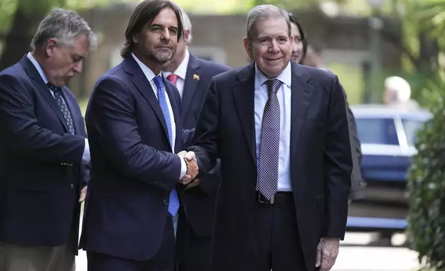 Venezuela's opposition leader Edmundo Gonzalez Urrutia, right, shakes hands with Uruguayan President Luis Lacalle Pou in Montevideo, Uruguay, Saturday, Jan. 4, 2025. Gonzalez, who claims he won the 2024 presidential election and is recognized by some countries as the legitimate president-elect, traveled from exile in Madrid to Argentina and Uruguay. (AP Photo/Matilde Campodonico)