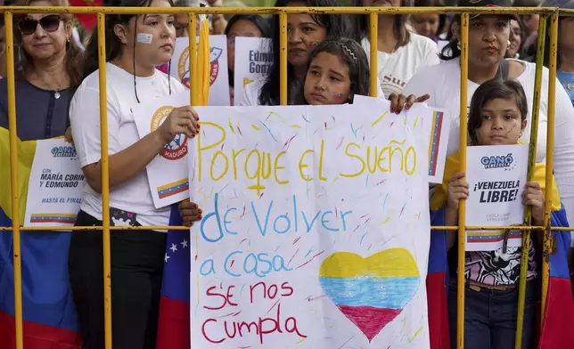 Supporters of Venezuela's opposition leader Edmundo Gonzalez Urrutia hold a banner reading in Spanish" Because the dream of returning home comes true" outside the government residence where he meets with Uruguayan President Luis Lacalle Pou in Montevideo, Uruguay, Saturday, Jan. 4, 2025. Gonzalez, who claims he won the 2024 presidential election and is recognized by some countries as the legitimate president-elect, traveled from exile in Madrid to Argentina and Uruguay. (AP Photo/Matilde Campodonico)