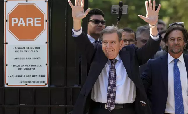 Venezuela's opposition leader Edmundo Gonzalez Urrutia, left, waves to supporters beside Uruguayan President Luis Lacalle Pou outside the government residence in Montevideo, Uruguay, Saturday, Jan. 4, 2025. Gonzalez, who claims he won the 2024 presidential election and is recognized by some countries as the legitimate president-elect, traveled from exile in Madrid to Argentina and Uruguay. (AP Photo/Matilde Campodonico)