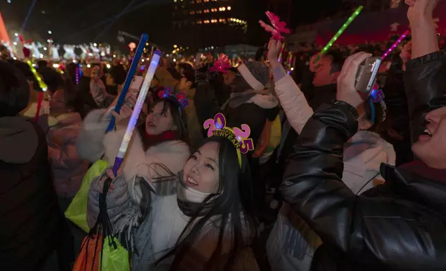 Revelers ring in the new year during a count down event held in Beijing, Wednesday, Jan. 1, 2025. (AP Photo/Ng Han Guan)