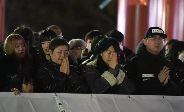 People pray on their traditional New Year's pilgrimage, at the main hall of Sensoji Buddhist temple, in Tokyo, Wednesday, Jan. 1, 2025. (AP Photo/Hiro Komae)