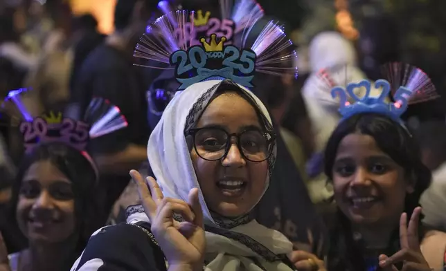 Revelers gather near the Petronas Twin Towers to watch the fireworks for the New Year's celebrations in Kuala Lumpur, Malaysia, Tuesday, Dec. 31, 2024. (AP Photo/Andy Wong)