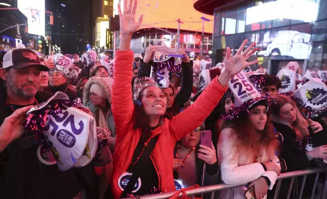 Revelers catch confetti from a performance during the annual New Year's Eve celebration in Times Square, Tuesday, Dec. 31, 2024, in New York. (AP Photo/Heather Khalifa)