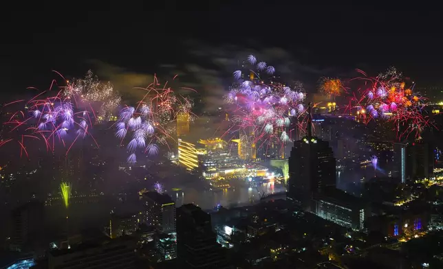 Fireworks explode over the Chao Phraya River during New Year celebrations in Bangkok, Thailand, Wednesday, Jan. 1, 2025. (AP Photo/Sakchai Lalit)