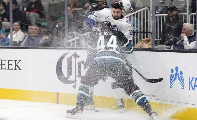 Tampa Bay Lightning left wing Nick Paul is checked into the boards by San Jose Sharks defenseman Marc-Edouard Vlasic (44) during the second period of an NHL hockey game in San Jose, Calif., Thursday, Jan. 2, 2025. (AP Photo/Tony Avelar)