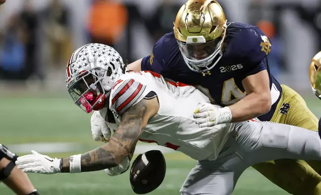 Notre Dame linebacker Drayk Bowen forces a fumble by Ohio State wide receiver Emeka Egbuka during second half of the College Football Playoff national championship game Monday, Jan. 20, 2025, in Atlanta. (AP Photo/Butch Dill)