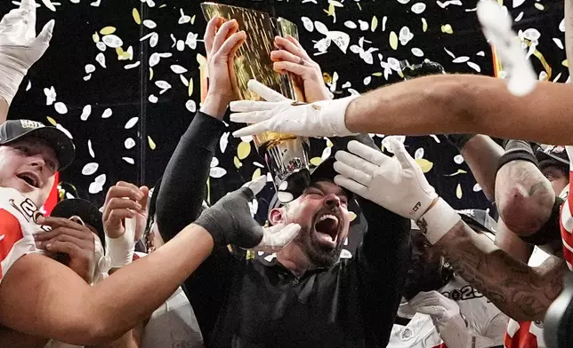 Ohio State head coach Ryan Day celebrates with the trophy after their win against Notre Dame in the College Football Playoff national championship game Monday, Jan. 20, 2025, in Atlanta. (AP Photo/Brynn Anderson)