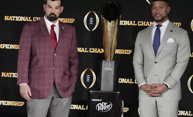 Ohio State head coach Ryan Day, left, and Notre Dame head coach Marcus Freeman pose with the trophy after a news conference ahead of the College Football Playoff national championship game Sunday, Jan. 19, 2025, in Atlanta. The game between Ohio State and Notre Dame will be played on Monday. (AP Photo/Chris Carlson)