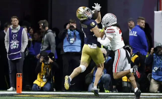 Notre Dame wide receiver Jaden Greathouse catches a touchdown pass ahead of Ohio State cornerback Jordan Hancock during second half of the College Football Playoff national championship game Monday, Jan. 20, 2025, in Atlanta. (AP Photo/Butch Dill)