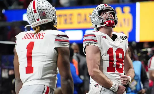 Ohio State quarterback Will Howard celebrates after a touchdown by running back Quinshon Judkins during second half of the College Football Playoff national championship game against Notre Dame Monday, Jan. 20, 2025, in Atlanta. (AP Photo/Jacob Kupferman)