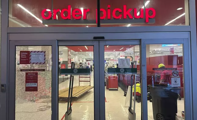 A broken window is seen at a Target store after two security guards were shot and wounded area after they confronted a man suspected of shoplifting in downtown Los Angeles on Tuesday, Dec. 31, 2024. (AP Photo/Damian Dovarganes)