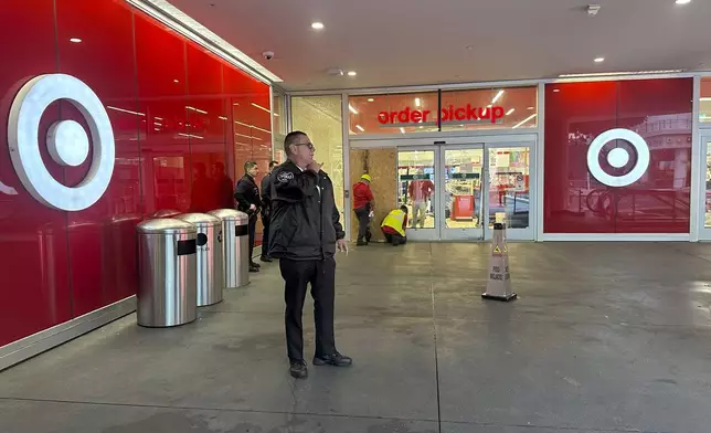 A security guard stands outside a Target store after two security guards were shot and wounded area after they confronted a man suspected of shoplifting in downtown Los Angeles on Tuesday, Dec. 31, 2024. (AP Photo/Damian Dovarganes)