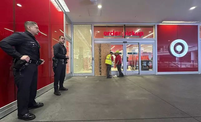 Los Angeles police stand outside a Target store after two security guards were shot and wounded area after they confronted a man suspected of shoplifting in downtown Los Angeles on Tuesday, Dec. 31, 2024. (AP Photo/Damian Dovarganes)