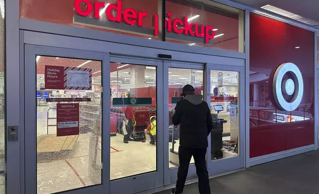 A man enters a Target store after two security guards were shot and wounded area after they confronted a man suspected of shoplifting in downtown Los Angeles on Tuesday, Dec. 31, 2024. (AP Photo/Damian Dovarganes)