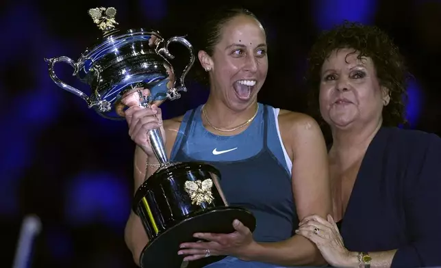 Madison Keys, center, of the U.S. reacts as she receives the the Daphne Akhurst Memorial Cup from Evonne Goolagong Cawley after defeating Aryna Sabalenka of Belarus in the women's singles final at the Australian Open tennis championship in Melbourne, Australia, Saturday, Jan. 25, 2025. (AP Photo/Ng Han Guan)