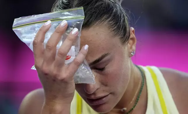 Aryna Sabalenka of Belarus places a bag of ice to her face during the women's singles final against Madison Keys of the U.S. at the Australian Open tennis championship in Melbourne, Australia, Saturday, Jan. 25, 2025. (AP Photo/Ng Han Guan)