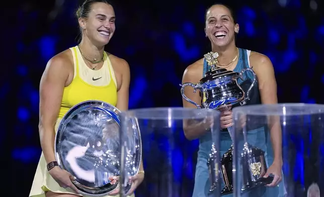 Madison Keys, right, of the U.S. reacts as she holds the Daphne Akhurst Memorial Cup after defeating Aryna Sabalenka, left, of Belarus in the women's singles final at the Australian Open tennis championship in Melbourne, Australia, Saturday, Jan. 25, 2025. (AP Photo/Asanka Brendon Ratnayake)