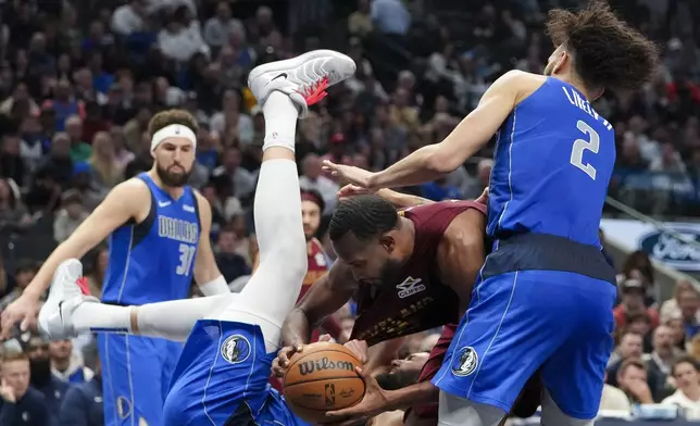 Cleveland Cavaliers forward Evan Mobley, center right, collides with Dallas Mavericks forward Maxi Kleber, second from left, while driving to the basket during the first half of an NBA basketball game, Friday, Jan. 3, 2025, in Dallas. Mavericks' Dereck Lively II (2) and Klay Thompson (31) look on. (AP Photo/Julio Cortez)