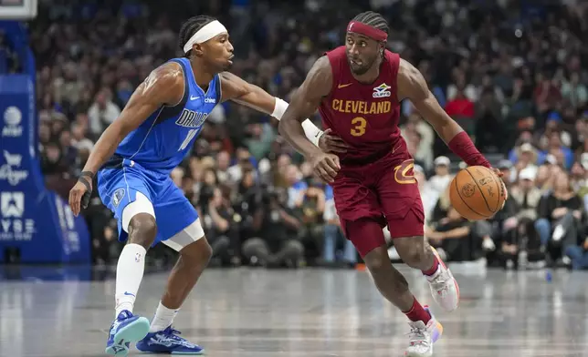 Cleveland Cavaliers guard Caris LeVert (3) drives against Dallas Mavericks guard Brandon Williams during the first half of an NBA basketball game, Friday, Jan. 3, 2025, in Dallas. (AP Photo/Julio Cortez)