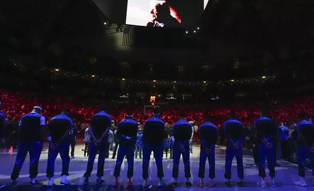 Dallas Mavericks players line up for a moment of silence honoring former President Jimmy Carter prior to an NBA basketball game against the Cleveland Cavaliers, Friday, Jan. 3, 2025, in Dallas. (AP Photo/Julio Cortez)