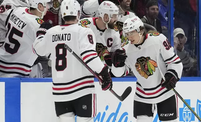 Chicago Blackhawks center Connor Bedard (98) celebrates his goal against the Tampa Bay Lightning with center Ryan Donato (8) during the second period of an NHL hockey game Tuesday, Jan. 28, 2025, in Tampa, Fla. (AP Photo/Chris O'Meara)
