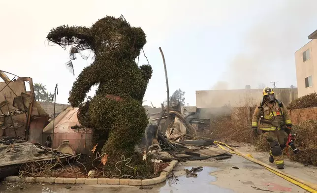 A firefighter walks past a charred bunny sculpture and debris at the destroyed Bunny Museum, Thursday, Jan. 9, 2025, in the Altadena section of Pasadena, Calif. (AP Photo/Chris Pizzello)