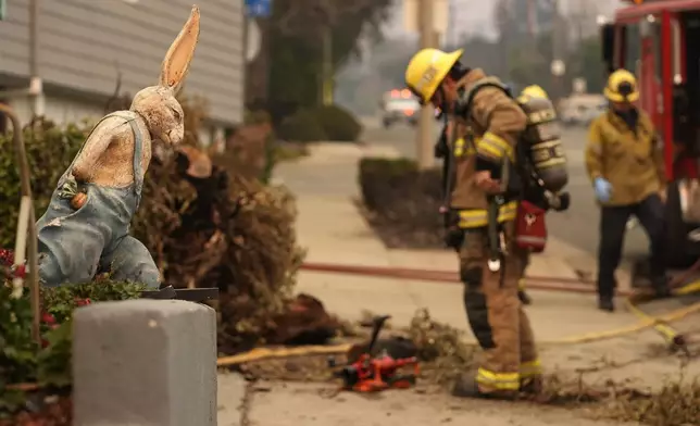 A firefighter looks at charred remains outside the destroyed Bunny Museum, Thursday, Jan. 9, 2025, in the Altadena section of Pasadena, Calif. (AP Photo/Chris Pizzello)