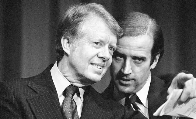 FILE - President Jimmy Carter listens to Sen. Joseph R. Biden, D-Del., as they wait to speak at fund raising reception at Padua Academy in Wilmington, Del., Feb. 20, 1978. (AP Photo/Barry Thumma, File)