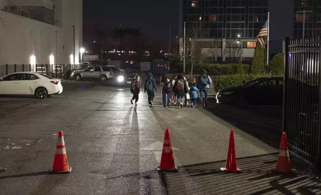 Gleydis Carvajal, and her husband, Gabriel Montilla, walk with their children from a bus stop to a migrant shelter in Queens after picking them up from school in Brooklyn, New York, Tuesday, Jan. 14, 2025. Carvajal and her family were recently relocated to a migrant shelter in Queens after the family shelter at Floyd Bennett Field was closed. (AP Photo/Klaus Galiano)