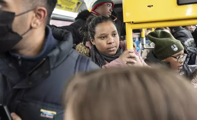 Ecuadorian Leidy Andrade rides a bus after picking up her children from their school in the Flatbush neighborhood of Brooklyn and commuting with them to a shelter in the Jamaica neighborhood of the Queens borough of New York, Tuesday, Jan. 14, 2025. Andrade and her family were recently relocated to a migrant shelter in Queens after the family shelter at Floyd Bennett Field was closed. (AP Photo/Klaus Galiano)