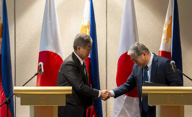 Japanese Foreign Minister Takeshi Iwaya, left, and Philippine Foreign Secretary Enrique Manalo shake hands after a joint press conference in Taguig City, Philippines Wednesday, Jan. 15, 2025. (Lisa Marie David/Pool Photo via AP)