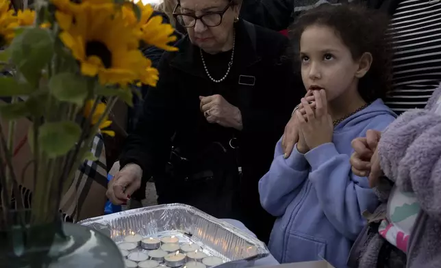 People gather to light candles for Shabbat in Tel Aviv, Israel, after Israel's security Cabinet recommended approval of a ceasefire deal after Prime Minister Benjamin Netanyahu confirmed an agreement had been reached that would pause the 15-month war with Hamas in Gaza and release dozens of hostages held by militants there, Friday, Jan. 17, 2025. (AP Photo/Maya Alleruzzo)