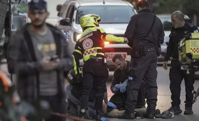 The body of a man who attacked and injured several pedestrians with a knife is examined by Israeli police after he was shot during the stabbing incident in Tel Aviv, Israel, Saturday Jan. 18, 2025.(AP Photo/Oded Balilty)