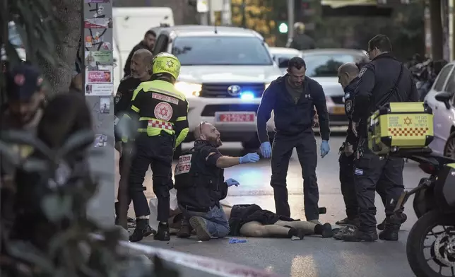 The body of a man who attacked pedestrians with a knife is examined by Israeli police after he was shot during the stabbing incident in Tel Aviv, Israel, Saturday Jan. 18, 2025.(AP Photo/Oded Balilty)