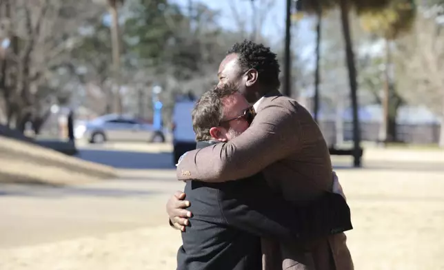 Republican South Carolina Rep. Brandon Cox from Goose Creek, left, and Democratic state Rep. Jermaine Johnson of Columbia, right, hug on the proposed site for a statue of Reconstruction hero Robert Smalls on Wednesday, Jan. 8, 2025, in Columbia, S.C. (AP Photo/Jeffrey Collins)