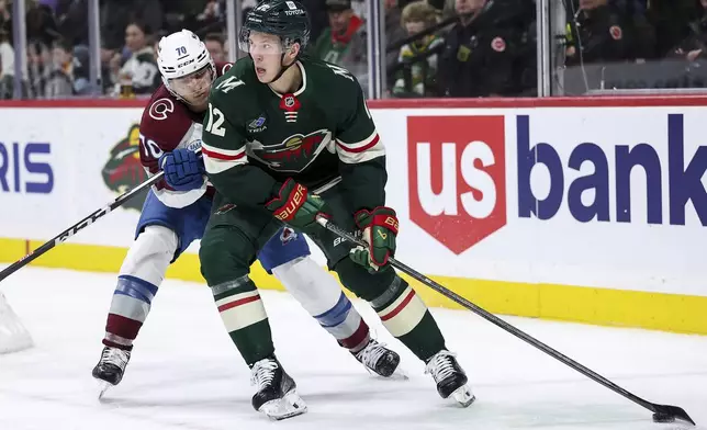 Minnesota Wild left wing Matt Boldy, right, skates with the puck as Colorado Avalanche defenseman Sam Malinski, left, defends during the second period of an NHL hockey game Thursday, Jan. 9, 2025, in St. Paul, Minn. (AP Photo/Matt Krohn)