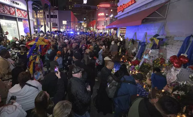 People crowd Bourbon Street near the intersection of Canal Street in New Orleans, Saturday, Jan. 4, 2025, as they memorialize the victims of the New Year's Day deadly truck attack and shooting. (AP Photo/Matthew Hinton)