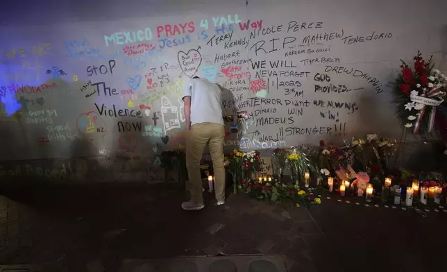 A friend of Kareem Badawi, a victim of the deadly truck attack on New Year's Day in New Orleans, pauses at a memorial for victims after attending his funeral, Friday, Jan. 3, 2025. (AP Photo/Gerald Herbert)