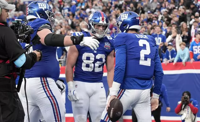 New York Giants quarterback Drew Lock (2) celebrates with tight end Daniel Bellinger (82) after Lock scored a touchdown against the Indianapolis Colts in the second half of an NFL football game Sunday, Dec. 29, 2024, in East Rutherford, N.J. (AP Photo/Seth Wenig)