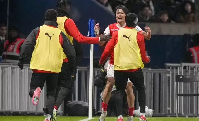 Reims' Keito Nakamura, celebrates with teammates after scoring his side's first goal during the French League One soccer match between Paris Saint-Germain and Reims at Parc des Princes stadium in Paris, Saturday, Jan. 25, 2025. (AP Photo/Michel Euler)