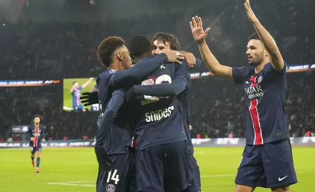 PSG's Ousmane Dembele, center, celebrates with teammates after scoring the opening goal during the French League One soccer match between Paris Saint-Germain and Reims at Parc des Princes stadium in Paris, Saturday, Jan. 25, 2025. (AP Photo/Michel Euler)