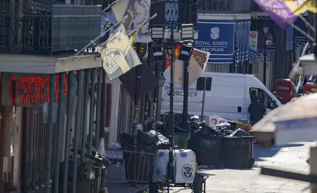 An Orleans Parish Coroner van is seen on Bourbon Street during the investigation of a pickup truck crashing into pedestrians on Bourbon Street in front of the Royal Sonesta Hotel in the French Quarter in New Orleans, Wednesday, Jan. 1, 2025. (AP Photo/Matthew Hinton)