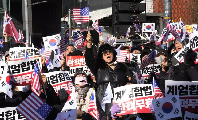 Supporters of impeached South Korean President Yoon Suk Yeol stage a rally to oppose a court having issued a warrant to detain Yoon, near the presidential residence in Seoul, South Korea, Thursday, Jan. 2, 2025. The signs read, "Oppose impeachment." (AP Photo/Ahn Young-joon)