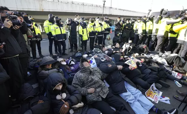 Supporters of impeached South Korean President Yoon Suk Yeol lie down on the ground as Yoon faces potential arrest after a court on Tuesday approved a warrant for his arrest, near the presidential residence in Seoul, South Korea, Thursday, Jan. 2, 2025. (AP Photo/Ahn Young-joon)