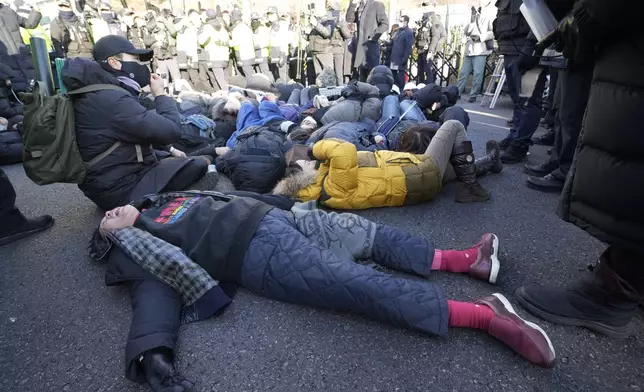 Supporters of impeached South Korean President Yoon Suk Yeol lie down on the ground as Yoon faces potential arrest after a court on Tuesday approved a warrant for his arrest, near the presidential residence in Seoul, South Korea, Thursday, Jan. 2, 2025. (AP Photo/Ahn Young-joon)