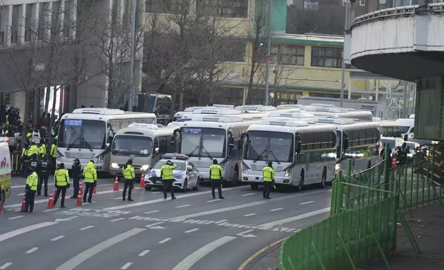 Police vehicles are seen near the gate of the presidential residence as supporters of impeached South Korean President Yoon Suk Yeol stage a rally to oppose a court having issued a warrant to detain Yoon, in Seoul, South Korea, Friday, Jan. 3, 2025. (AP Photo/Lee Jin-man)