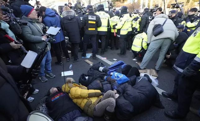 Supporters of impeached South Korean President Yoon Suk Yeol lie down on the ground as Yoon faces potential arrest after a court on Tuesday approved a warrant for his arrest, near the presidential residence in Seoul, South Korea, Thursday, Jan. 2, 2025. (AP Photo/Ahn Young-joon)