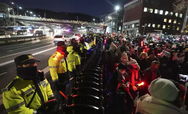 Supporters of impeached South Korean President Yoon Suk Yeol stage a rally to oppose a court having issued a warrant to detain Yoon, as police offices stand guard near the presidential residence in Seoul, South Korea, Friday, Jan. 3, 2025. (AP Photo/Lee Jin-man)